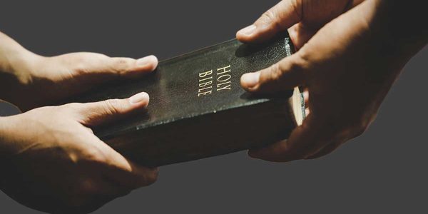 word-worship-bible Two hands holding Bible worshipping